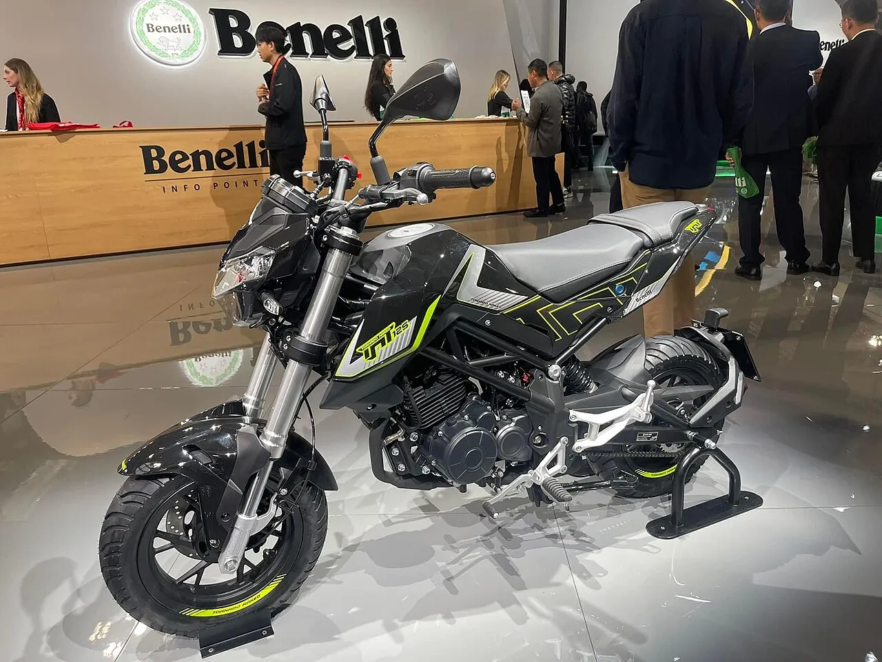 Benelli TNT 125 hitam dengan aksen hijau dipajang di stan Benelli, mesin dan rangka terlihat dari samping