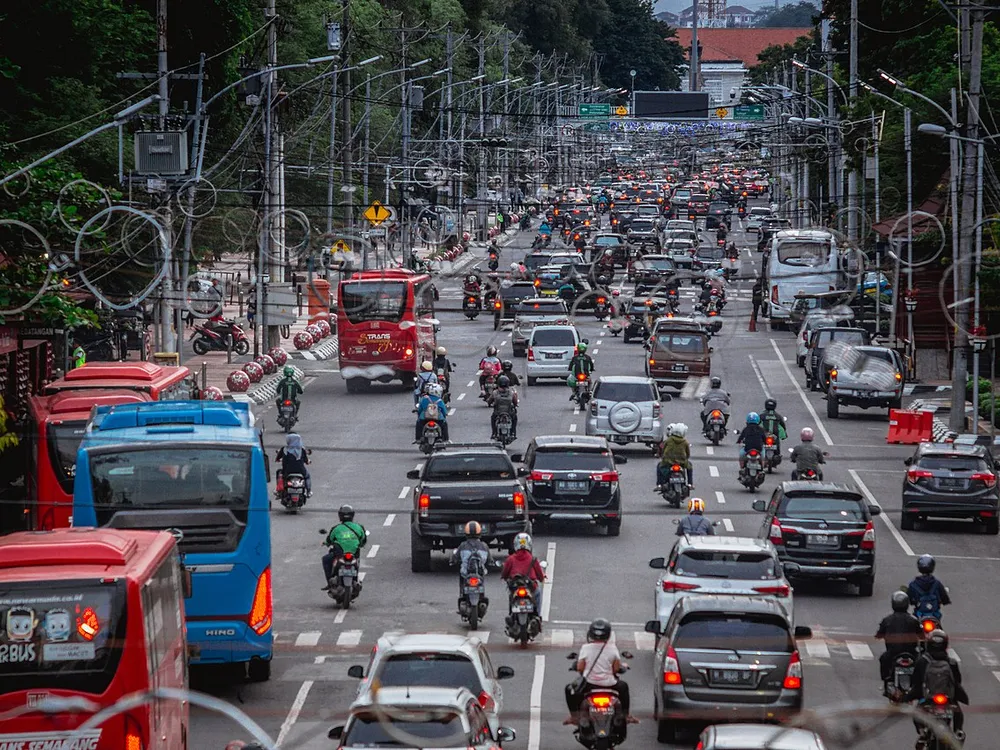 Lalu lintas padat di Jalan Pemuda, Kota Semarang, dengan bus kota merah, mobil pribadi, dan sepeda motor di beberapa lajur