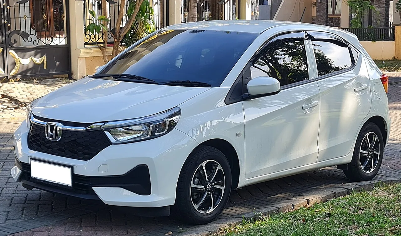 Honda Brio Satya E generasi kedua berwarna putih dilihat dari depan kiri, terparkir di depan rumah dengan velg alloy dua warna 14 inci