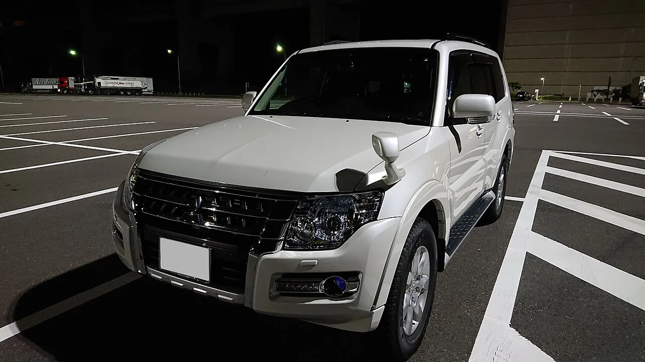 Mitsubishi Pajero Final Edition putih tampak depan samping di area parkir pada malam hari