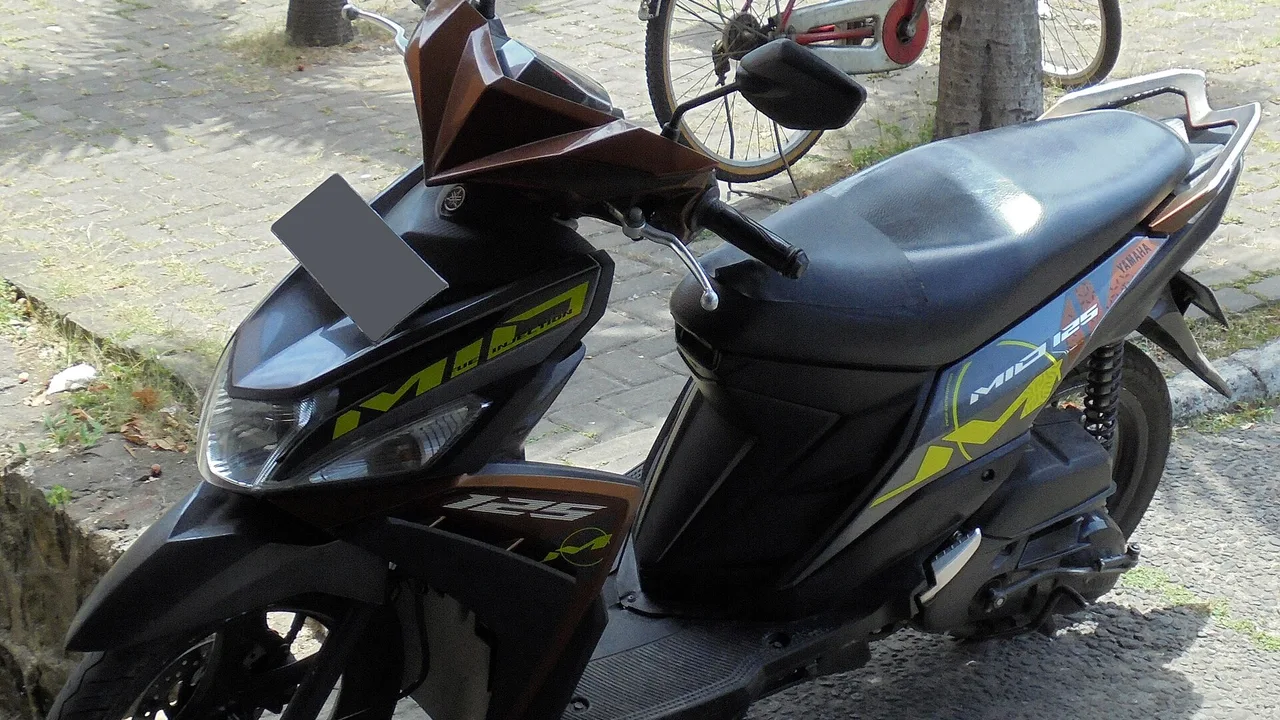 Yamaha Mio M3 125 hitam dengan aksen cokelat dan stiker hijau muda bertulisan Mio 125, plat nomornya ditutup kotak abu-abu