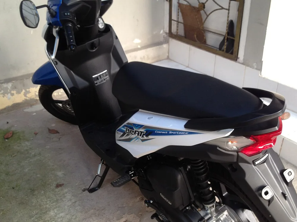 Honda BeAT eSP putih biru dilihat dari belakang samping, terparkir di teras rumah berlantai keramik